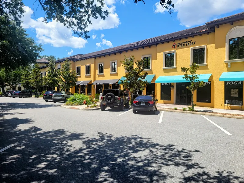 The front of 142 W. Lakeview Avenue, Lake Mary, FL &mdash; a yellow two-storey building with awnings, opposite Central Park